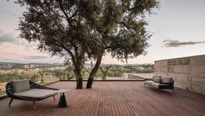 A wooden deck with two sofas and a table, overlooking a scenic landscape. - Haven Nature Villa II by Feel Discovery (Batalha)