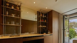 A modern kitchen with built-in shelves, a large window, and a seating area.