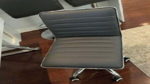 A modern office chair with a high backrest and metal legs.
