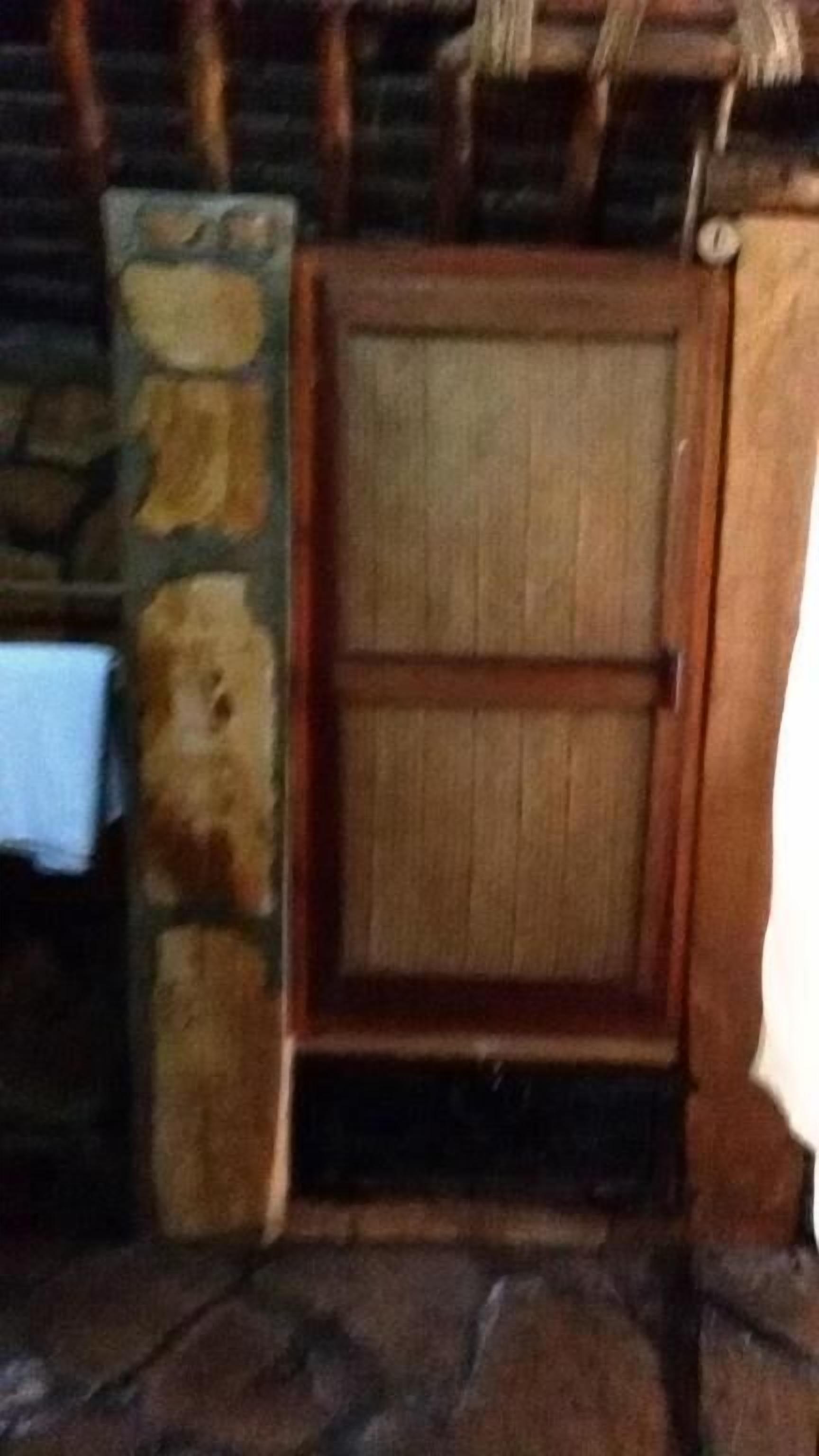 Una porta in legno con un muro in pietra e un piccolo gradino che conduce ad essa.