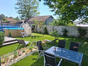 A backyard with a swimming pool, a play area, and a dining table with chairs. - T2 apartment for rent 7Km from the ocean (Notre-Dame-de-Riez)