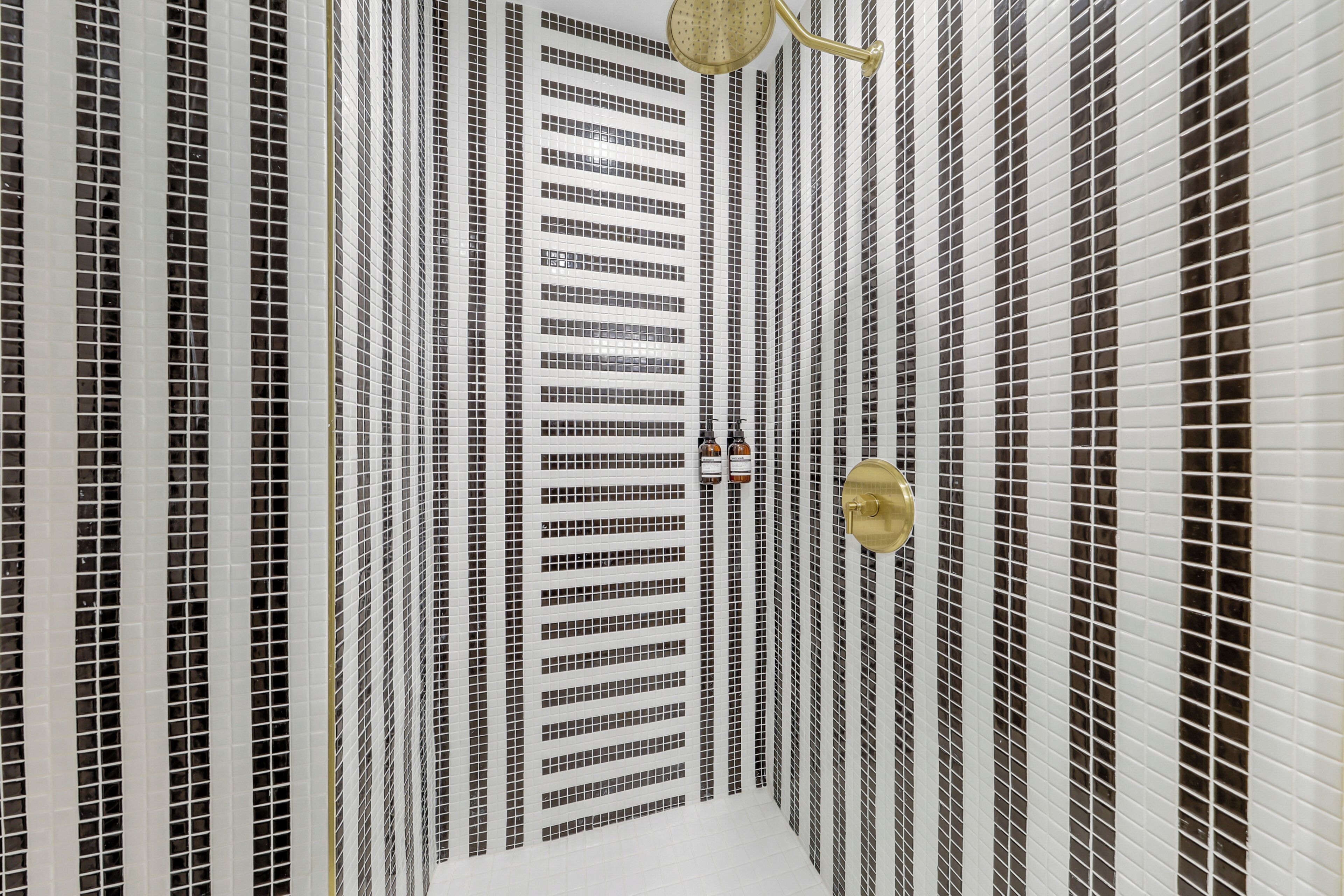 A room with a tiled floor, a central column, and a ceiling with a light fixture.