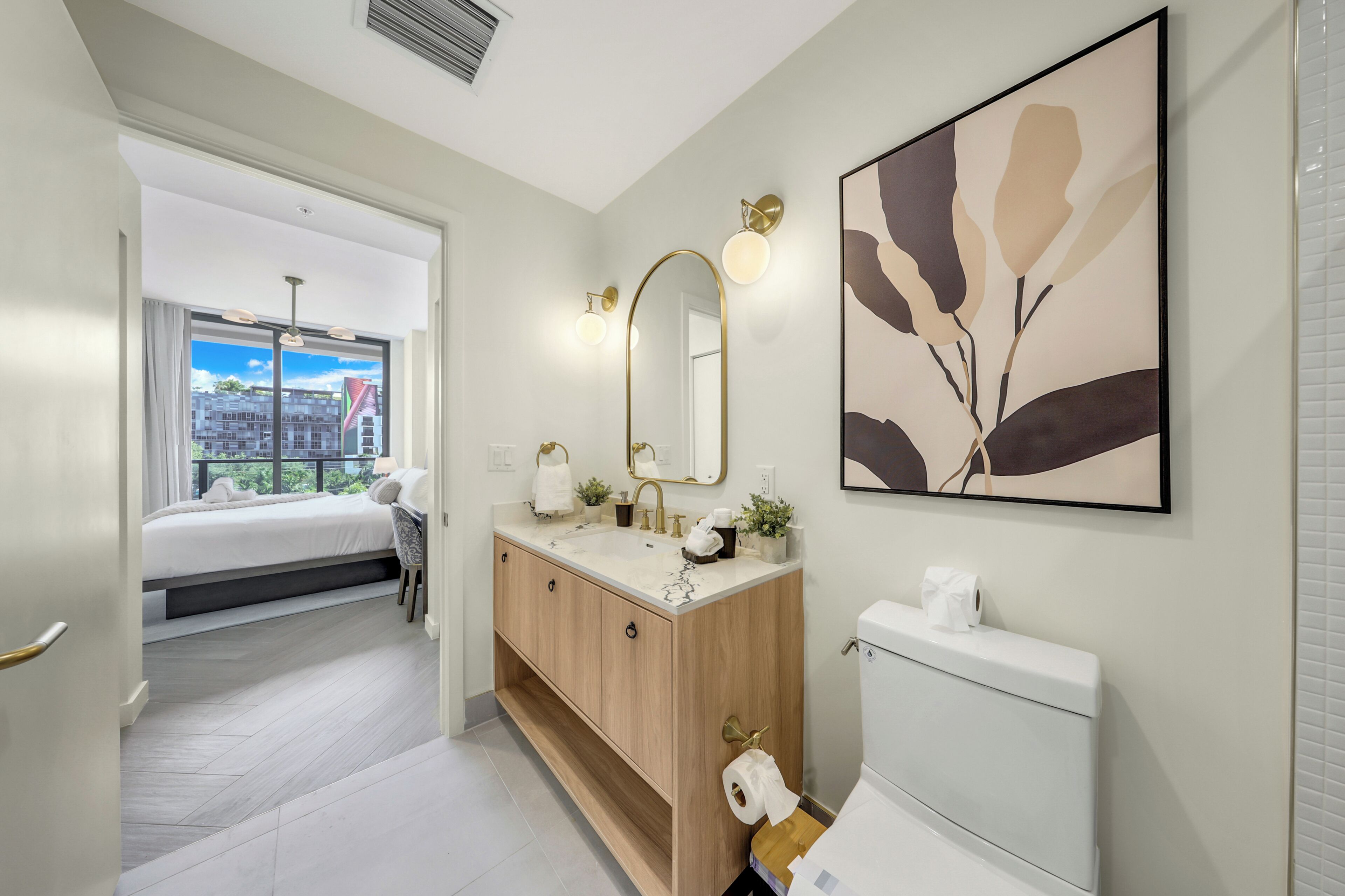 Une salle de bain moderne avec un grand miroir, des toilettes et un lavabo.