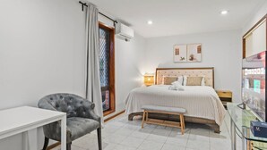 Una camera da letto con un letto, un comodino, una sedia e una televisione.