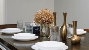 Una tavola imbandita con piatti, bicchieri e vasi decorativi.