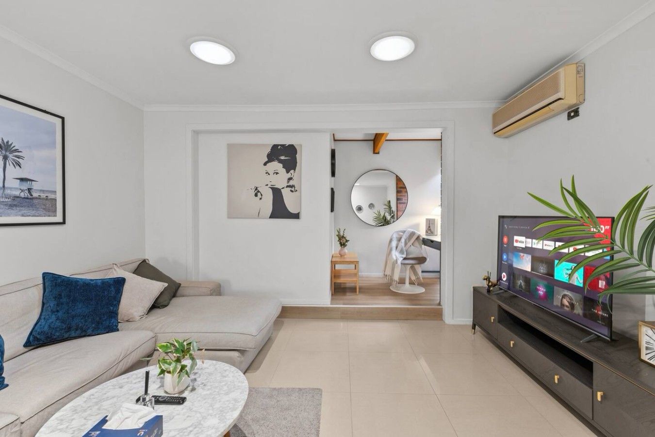 Un salon moderne avec un canapé, une table basse et un téléviseur.