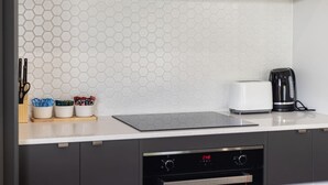 A modern kitchen with a white countertop, a toaster, a coffee maker, and a dishwasher. - Brand New Family Home | Space, Comfort & Location (Park Ridge)