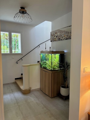 A staircase with a fish tank, a wooden cabinet, a potted plant, and a wall-mounted picture. - Provencal house with large swimming pool. Close to the sea! (La Garde)