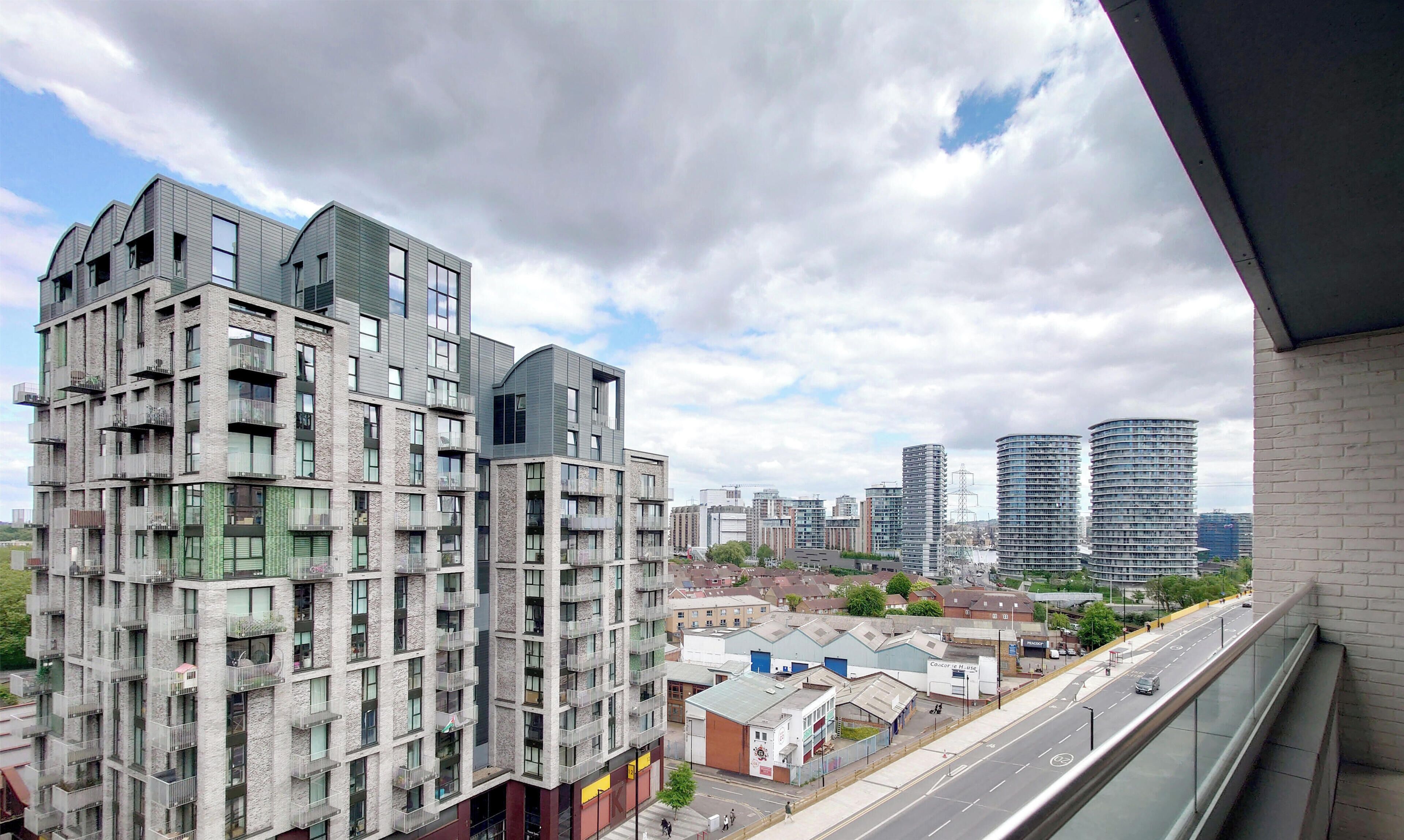 A high-rise building with multiple balconies and a view of a cityscape.