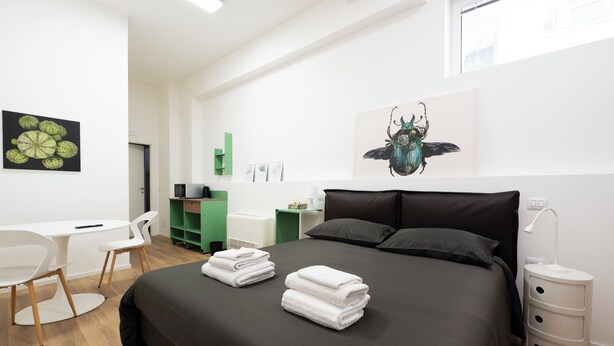 Un dormitorio moderno con cama, escritorio y silla.