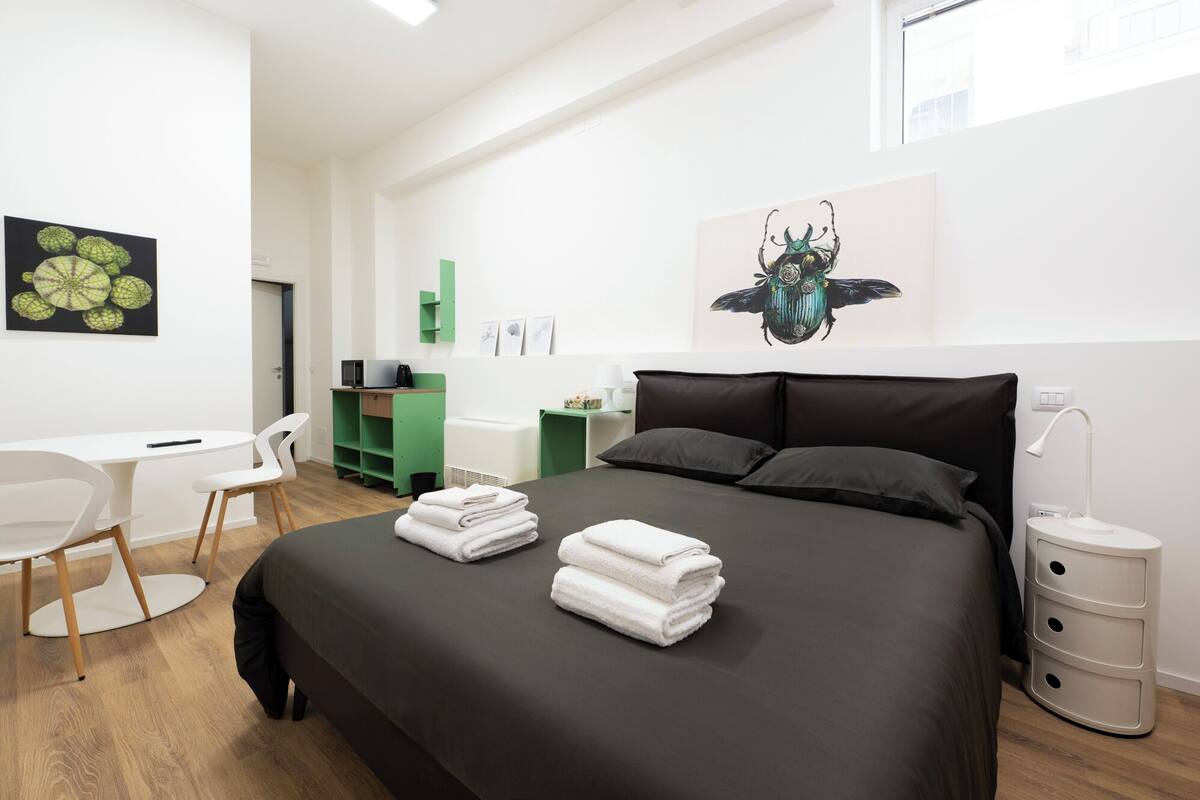 A modern bedroom with a bed, a desk, and a chair.