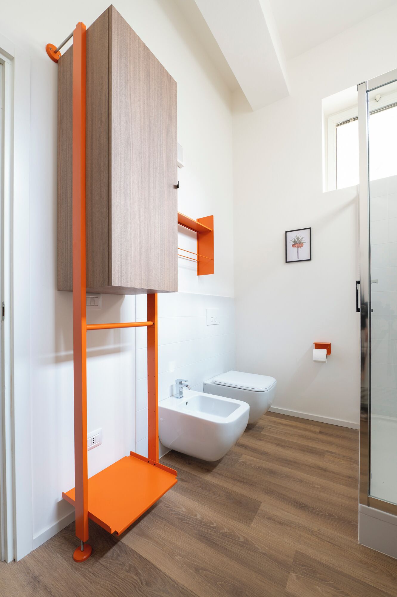 A modern bathroom with a wooden vanity, a bidet, and a toilet.