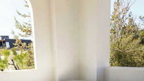Ein Whirlpool mit Bläschen, einem Fenster und Blick auf Bäume sowie ein Gebäude.