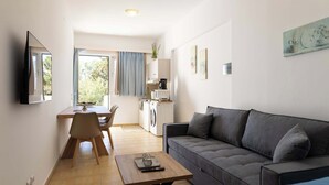 Un salon comprenant un canapé, une table basse et un coin repas avec une table et des chaises.