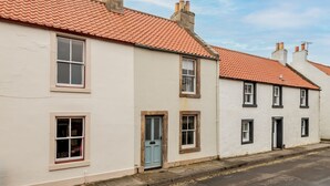 A row of white buildings with red-tiled roofs and multiple windows. - Devon Cottage | Elie (Elie)
