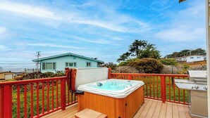 A deck with a hot tub, barbecue grill, and a view of a house. - Bodega Bay 2BR ocean-view cottage with hot tub — dog friendly (Bodega Bay)