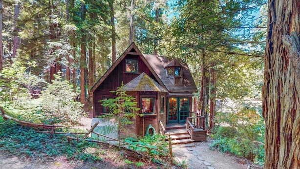 A cabin surrounded by tall trees, with a wooden exterior and a small porch. - Cazadero 1BR A-frame cabin with hot tub for two — dog friendly (Cazadero)
