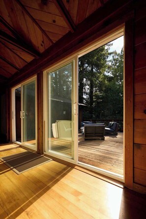 A wooden interior with a sliding glass door leading to an outdoor deck. - Forestville 3BR redwood cabin with gas fireplace, fire pit & deck (Forestville)
