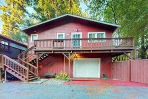 A two-story red building with a balcony, a garage, and a staircase.