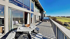 Una casa moderna con terraza, ventanas amplias y vistas al campo.