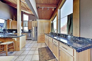 Eine Küche mit Holzschränken, einer Granit-Arbeitsplatte und einem Kühlschrank.