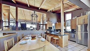 Una cocina amplia con una isla grande, armarios de madera y un refrigerador de acero inoxidable.
