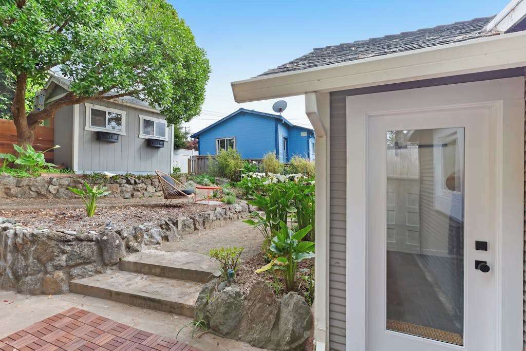 A residential area with a house, a garage, and a garden with steps leading to the house.