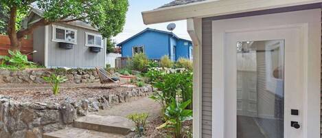A residential area with a house, a garage, and a garden with steps leading to the house.