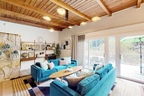 A modern living room with a blue sofa set, a coffee table, and a wooden ceiling.
