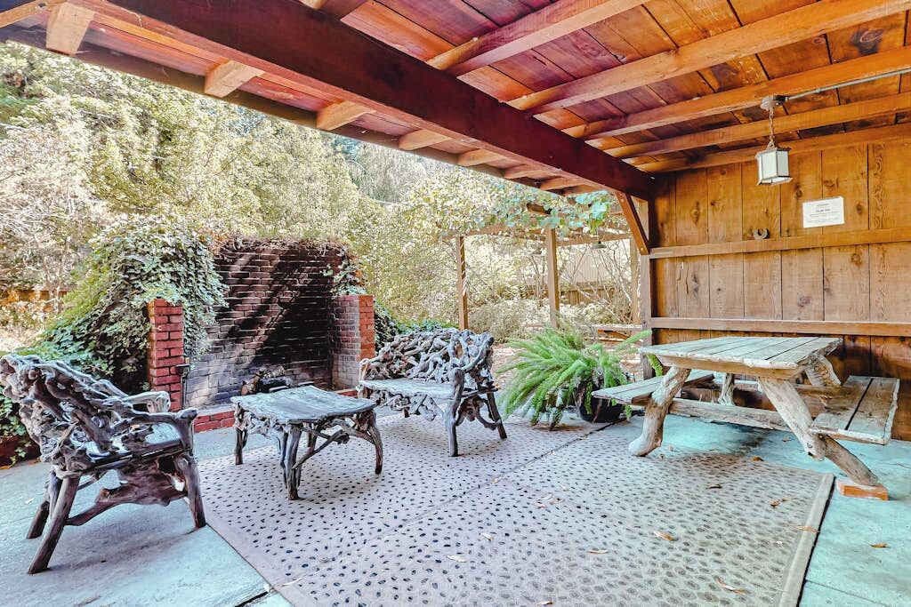 Unwind beneath your private covered patio — wrought-iron seating, a brick hearth, and a picnic table set the scene for lazy redwood afternoons along the Russian River.