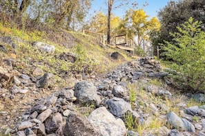 A rocky outdoor area with a wooden staircase leading up a hill.