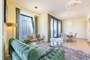 A spacious living room with a green sofa, a round coffee table, and a dining area with chairs and a table. -     3BR Burj Khalifa View with balcony (Dubai)