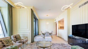 Una sala de estar moderna con un sofá verde, una mesa de centro redonda de vidrio y un televisor de pantalla plana.