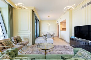 A modern living room with a green sofa, a round glass coffee table, and a flat-screen TV. -     3BR Burj Khalifa View with balcony (Dubai)
