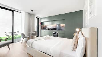 Une chambre d’hôtel moderne dotée d’un grand lit, d’un coin repas et d’une cuisine.