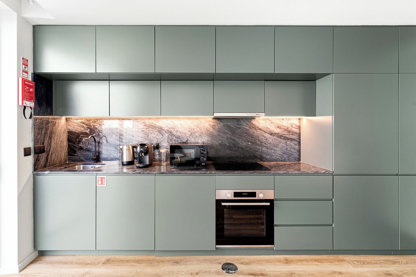 Eine moderne Küche mit Marmorrückwand, integrierten Geräten und einem minimalistischen Design.