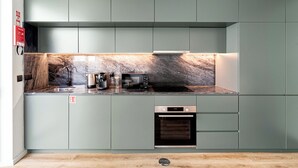 Eine moderne Küche mit Marmorrückwand, integrierten Geräten und einem minimalistischen Design.
