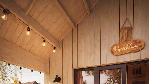 A wooden interior with a ceiling light fixture and a sign reading 'Pusteblume.' - Tiny House Pusteblume with Private Terrace and Wi-Fi (Wesseln)