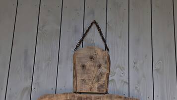 A wooden sign with the text 'Pusteblume' mounted on a wall with vertical wooden planks.