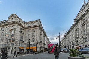 A street scene with a red double-decker bus, historic buildings, and pedestrians. - Entire Apartment in the Heart of Soho London// Best location in London (London)