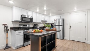 Een moderne keuken met witte kasten, roestvrijstalen apparatuur en een centraal eiland.