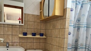 A bathroom with a white sink, toilet, and shower curtain.