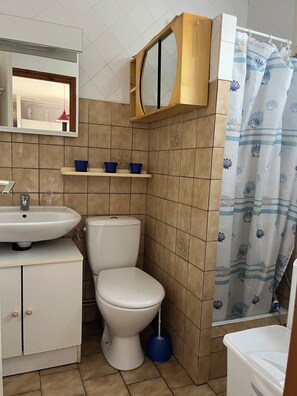 A bathroom with a white sink, toilet, and shower curtain.