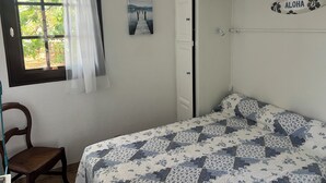 A bedroom with a bed, a chair, a window with curtains, a door, and a wall-mounted sign. - Quiet house near the ocean (Biscarrosse)
