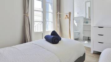 Une chambre d’hôtel avec un lit, une armoire, une fenêtre avec des rideaux et une vue sur l’extérieur.
