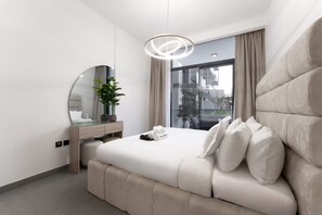 Een moderne hotelkamer met een groot bed, een nachtkastje met spiegel, een plant in pot en uitzicht op de stad door het raam.