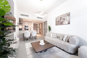 Een moderne woonkamer met een bank, salontafel en een eethoek.
