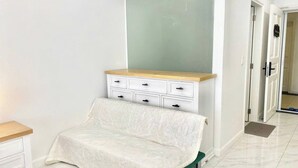 A bedroom with a bed, a dresser, and a door. - Căn Hộ View Biển (Phú Thủy)