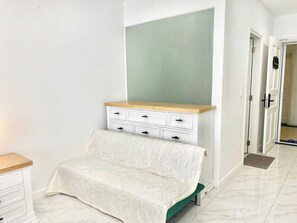 A bedroom with a bed, a dresser, and a door.