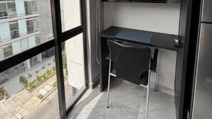 Una habitación moderna con escritorio, silla y televisor de pantalla plana en la pared.